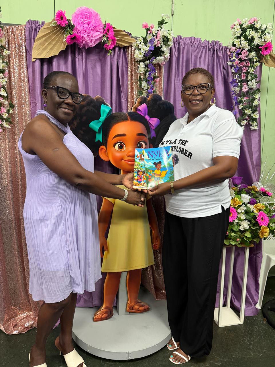 Pearlette Primus Hannaway presenting the Nyla the TVET Explorer books beside a life-size Nyla figure